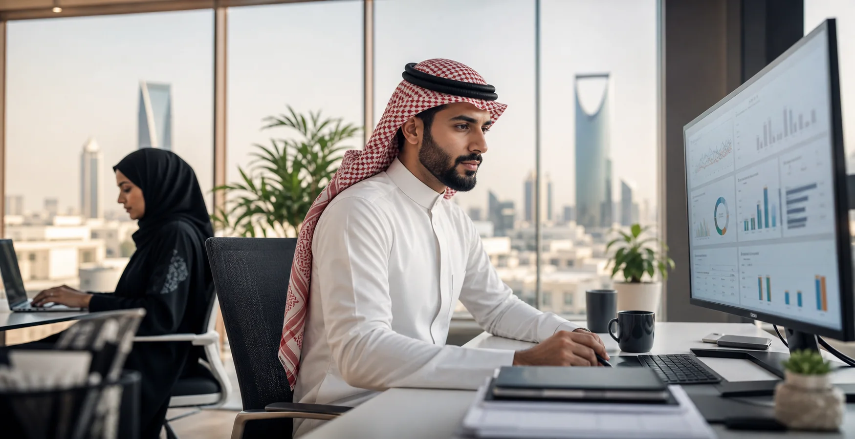 Saudi supply chain professional reviewing a planning and inventory dashboard in Riyadh