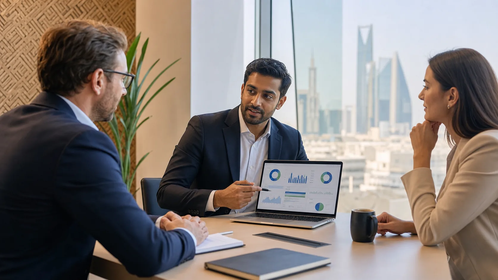 International professionals reviewing an Excel dashboard in a Saudi office