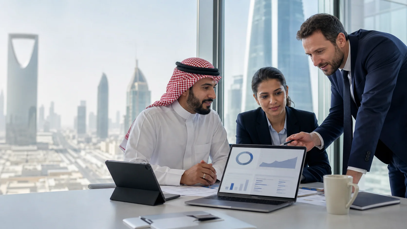 Information security professionals reviewing ISMS implementation progress in Riyadh